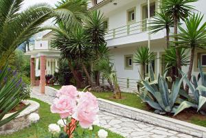 una casa con palme e fiori rosa nel cortile di Villa Marinos a Kato Korakiana
