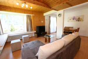 a living room with a couch and a tv at Apartment Bünda in Davos