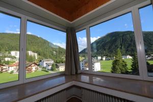 a room with windows with mountains in the background at Apartment Bünda in Davos
