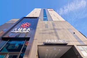 a tall building with a parking sign on it at Gwangju Aura Hotel in Gwangju