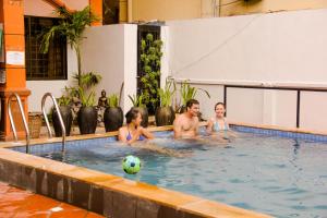 un grupo de personas en una piscina con una pelota en Tropical Breeze en Siem Riep