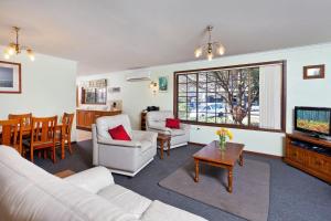 a living room with a couch and a tv and a table at Byron Bay Accom Marvel St Byron Bay in Byron Bay