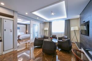 a hotel room with a bed and a table and chairs at Gwangju Aura Hotel in Gwangju