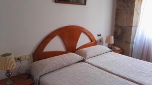 a bedroom with a bed with a wooden headboard at Hostal Continental in Vigo +18 photos