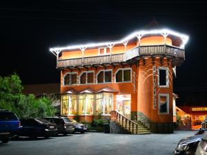 um edifício com uma varanda em cima à noite em Vila Belvedere em Hateg
