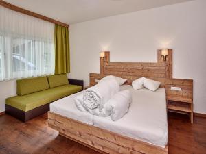 sypialnia z dużym łóżkiem i zieloną kanapą w obiekcie A Casa Saphir Appartement-Hotel w Solden