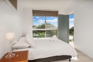 A bed or beds in a room at Byron Bay Accom 13 Brownell Drive Wategos Beach - Beach House