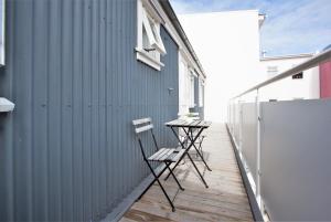 dos sillas sentadas en una terraza junto a un edificio en Odinn Reykjavik Odinsgata Apartments, en Reikiavik