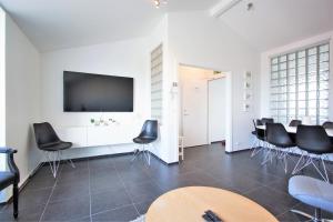 a meeting room with black chairs and a flat screen tv at Odinn Reykjavik Odinsgata Apartments in Reykjavík