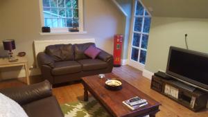 a living room with a couch and a coffee table at The Garden Cottage, 17th Century, hottub, parking, wifi in Telford