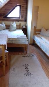 プライドにあるPensiunea AMALIA Panzióのベッド2台と敷物が備わる客室です。