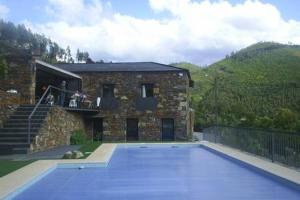 une maison avec une piscine en face d'un bâtiment dans l'établissement Passadiço Art and River House, à Paradinha