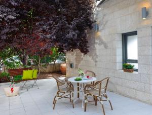 un patio con mesa y sillas y un edificio en Rafael Residence Boutique, en Jerusalén