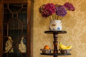 a vase with flowers on a table next to a wall at Dunmore Gardens in Carrigans