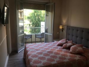 a bedroom with a bed with a view of a balcony at Hotel Enrico in Alassio