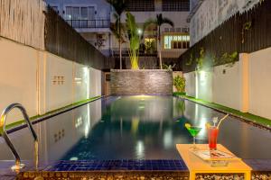 a swimming pool with a table and drinks on it at JK Resident in Siem Reap