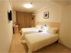 Ein Bett oder Betten in einem Zimmer der Unterkunft Jinjiang Inn - Qingdao Zhongshan Road