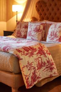 a neatly made bed with pillows and pillows at Relais Sant'Elena in Bibbona