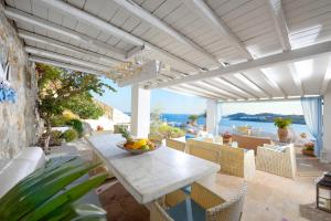 a patio with a table and chairs and the ocean at La Vie In Blue in Ornos