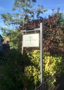 a sign in front of a tree at Weston Cottage in Poole