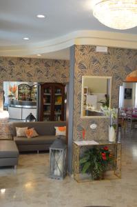 Hotel Dear Rimini في ريميني: غرفة معيشة مع أريكة ومرآة