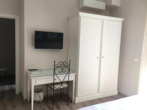 a room with a desk and a tv on a wall at Hotel Enrico in Alassio