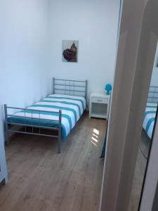 マリーニャ・グランデにあるCasa do Centroの小さなベッドルーム(ベッド1台、鏡付)