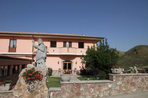a statue of a man on a rock in front of a house at Monte San Giovanni-Nebrodi Rooms in San Marco dʼAlunzio