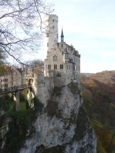 um castelo no topo de uma montanha com uma ponte em Hotel Germania em Reutlingen