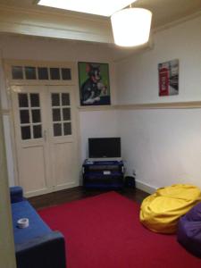 a living room with a blue couch and a tv at Covilhã Hostel in Covilhã