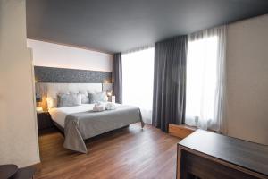 a bedroom with a bed and a large window at Petit Palace Museum in Barcelona