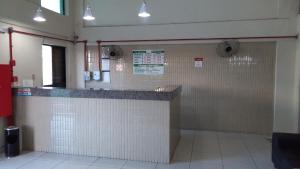 a restaurant with white tile walls and a counter at Hotel Parnaiba in Timon