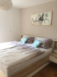 Illschwang的住宿－格魯恩公寓，卧室配有带蓝色枕头的大型白色床
