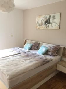 a bedroom with a large white bed with blue pillows at Ferienwohnung Im Grünen in Illschwang