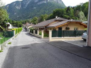 a house with a fence next to a driveway at Studio de la corbaz in Scionzier