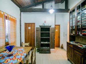 een eetkamer met een tafel en een plank met wijnflessen bij Ilha House Suítes in Ilhabela