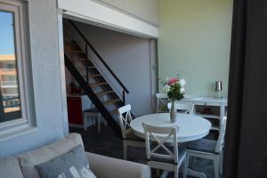 uma sala de estar com uma mesa e uma escada em Appartement Antinea em Cap d'Agde