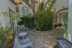 a courtyard with a tree and a table and chairs at Casa do Museu, Three Independent Properties in Cascais