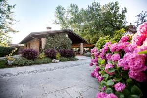 una casa con fiori rosa davanti di Hotel Al Posta a Casarsa della Delizia Altre 94 foto