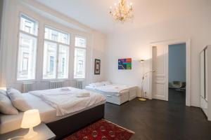sypialnia z 2 łóżkami i żyrandolem w obiekcie Grand Soho Apartment w Wiedniu