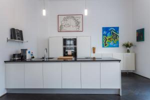 kuchnia z białymi szafkami i czarnym blatem w obiekcie Grand Soho Apartment w Wiedniu