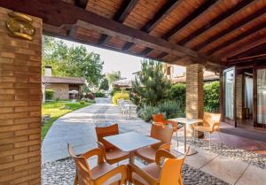 a patio with tables and chairs on a patio at Hotel Al Posta in Casarsa della Delizia