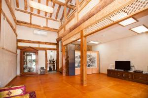 a large living room with wooden ceilings and a television at The Hanok in Jeonju