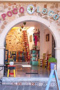 een toegang tot een restaurant met een stenen muur bij Poco Loco Bed & Breakfast in Chania