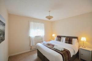 a bedroom with a large bed and a window at Harbour House - Donnini Apartments in Ayr