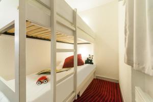 - une chambre pour enfants avec des lits superposés et une voiture jouets dans l'établissement Résidence Pierre & Vacances La Daille, à Val dʼIsère