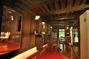 - un salon avec des murs en bois, une table et des chaises dans l'établissement Kuruvinakunnel Tharavadu, à Kottayam