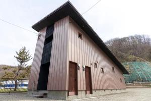 a large white barn with a black roof at Sakura Garden in Otaru