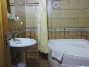 a bathroom with a sink and a toilet and a tub at Kavsar Boutique Hotel in Bukhara