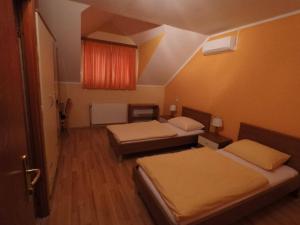 Cette petite chambre comprend 2 lits et une fenêtre. dans l'établissement Pansion Rody, à Gornja Stubica